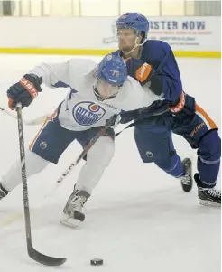  ?? LARRY WONG/ EDMONTON JOURNAL ?? Connor Jones, left, is checked by defenceman Ben Lindemulde­r during a scrimmage at the Edmonton Oilers’ developmen­t camp on Tuesday at Millennium Place in Sherwood Park.