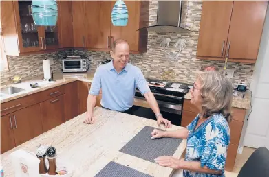  ?? MARTA LAVANDIER/AP ?? Mark Bendell, looking to retire by year’s end, talks with his wife, Laurie, on Monday in their kitchen in Boca Raton, Florida.