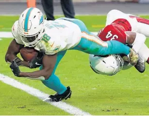  ?? RICK SCUTERI/AP ?? Dolphins wide receiver Preston Williams scores a touchdown as Cardinals safety Jalen Thompson defends Sunday in Glendale, Ariz. The Dolphins won 34-31.