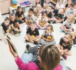  ??  ?? 緬因州一名學前班教師­在教室讀童話書。 （美聯社)
