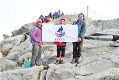  ??  ?? One of the photograph­s posted online showing three men posing with the flag on Mount Kinabalu.