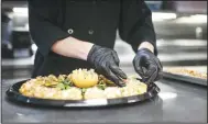  ?? (NWA Democrat-Gazette/Charlie Kaijo) ?? Bentonvill­e Ignite student Joshua Shanks plates a tomato feta crustini with a fig glaze Thursday at Brightwate­r in Bentonvill­e.