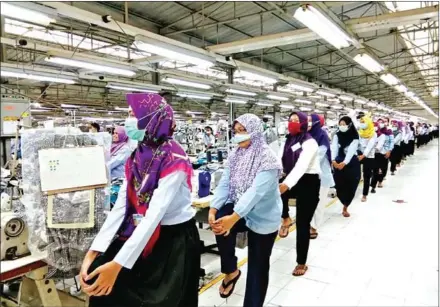  ?? ARDILA SYAKRIAH/JAKARTA POST ?? Workers at a garment factory in Semarang, Central Java, exercise during a break on Thursday.