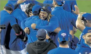  ?? AP ?? Toronto Blue Jays first baseman Vladimir Guerrero Jr., center, and teammates celebrate a 4-1 win over the New York Yankees in a game in Buffalo, N.Y., Thursday. Toronto clinched a postseason berth with the win.