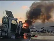  ?? PHOTO COURTESY OF MICHIGAN STATE POLICE TWITTER FEEDS ?? Michigan State Police shared this video of a car burning while a trooper tends (on the right side) to the man he pulled from the car after the accident on a slick overpass.