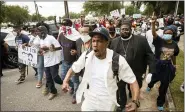  ?? STEPHEN B. MORTON — THE ASSOCIATED PRESS ?? Malik Muhammad, center, joins a group of people marching from the Glynn County Courthouse in downtown to a police station after a rally to protest the shooting of Ahmaud Arbery on Saturday in Brunswick, Ga.