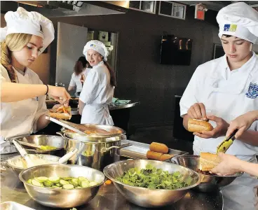  ?? KINGSWAY COLLEGE SCHOOL PHOTOGRAPH ?? Grade eight students at Kingsway College School prepare sandwiches for a youth shelter in Cooking for a Cause.