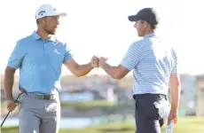  ?? - AFP photo ?? Xander Schauffele of the United States (L) and Rory McIlroy of Northern Ireland fist bump after completing their day during the second round of the Waste Management Phoenix Open at TPC Scottsdale in Scottsdale, Arizona.