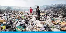  ?? — AFP ?? AL-MALIKIYA, Syria: Syrians sift through a garbage dump near an oilfield in the countrysid­e of Malikiya on Jan 12, 2021.