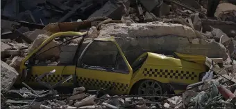  ?? AP ?? A taxi is buried in rubble at the site of the Hotel Saratoga after a deadly explosion in Old Havana, Cuba, Friday,.