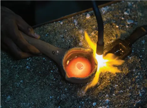  ??  ?? above A worker uses a blowtorch to purify gold near the end of the refining process. right A member of a family-owned refinery in Marmato holds a gold ingot.