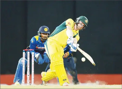  ??  ?? Australia’s Travis Head (right), plays a shot as Sri Lanka’s wicketkeep­er Dinesh Chandimal (left), looks on during the second One-Day Internatio­nal (ODI) cricket
match between Sri Lanka and Australia at the R. Premadasa Internatio­nal Cricket Stadium...