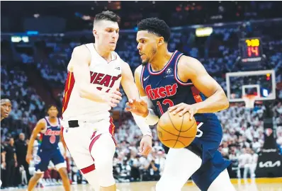  ?? Associated Press ?? ■ Philadelph­ia 76ers forward Tobias Harris (12) drives to the basket as Miami Heat guard Tyler Herro (14) defends, during the first half of Game 1 of an NBA basketball second-round playoff series Monday in Miami.