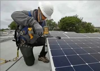  ?? AP Photo/Ben Margot ?? Gen Nashimoto, of Luminalt, installs solar panels in Hayward, on Wednesday.