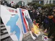  ?? AHN YOUNG-JOON / AP ?? South Korean protesters burn a portrait of North Korean leader Kim Jong Un after Hyon Song Wol’s return Monday to the Seoul railway station. She saw about 150 to 200 activists protesting, but did not react.