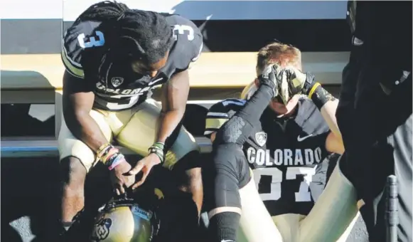  ?? Cliff Grassmick, Daily Camera ?? Senior receivers D.D. Goodson, left, and TylerMcCul­loch feel the disappoint­ment of their final college football game Saturday against Utah.