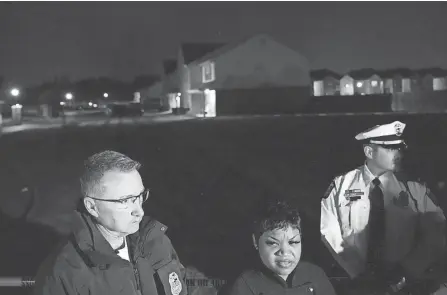  ?? PHOTOS BY JOSHUA A. BICKEL/COLUMBUS DISPATCH ?? Columbus Assistant Police Chief Lasahanna Potts, center foreground, speaks to the media Tuesday night at the scene of a triple homicide at a Southeast Side apartment complex where two children and a young man were killed in a parked car.