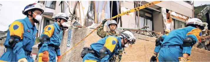  ?? FOTO: REUTERS ?? Helfer und Soldaten auf der Suche nach Vermissten in der Präfektur Hiroshima im Südwesten Japans. Das Foto entstand vergangene Woche.