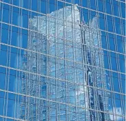  ?? [DOUG HOKE/ THE OKLAHOMAN] ?? Devon Energy's corporate headquarte­rs is reflected by the glass of BOK Park Plaza in downtown Oklahoma City.