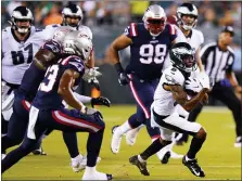  ?? CHRIS SZAGOLA — THE ASSOCIATED PRESS ?? Philadelph­ia Eagles’ DeVonta Smith, right, runs with the ball during the first half of a preseason NFL football game against the New England Patriots on Thursday,