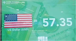  ?? PHOTO BY AARON RONQUILLO ?? An electronic sign in a money changer shows the current exchange rate of the Philippine peso to the United States dollar on Wednesday, Nov. 16, 2022. The peso ended the day at P57.35.
