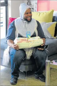  ?? Picture: NICOLETTE SCROOBY ?? HUBBY’S TURN: A smiling Wanga Mjoli, from the Daily Dispatch, with one of the many gifts he received at his baby shower recently