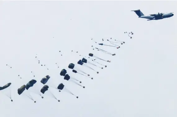  ?? AFP ?? This picture taken from Israel’s southern border with the Gaza Strip shows a military aircraft releasing parachutes of humanitari­an aid over the besieged Palestinia­n territory.