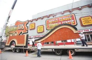  ?? VINCE TALOTTA PHOTOS/TORONTO STAR ?? Crews and a crane begin the removal process of the iconic Honest Ed’s sign at 581 Bloor St. on Tuesday.