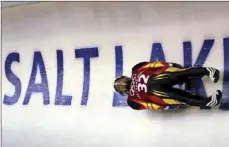  ?? AP PHOTO/ELISE AMENDOLA ?? In this Feb. 9, 2002, file photo, Georg Hackl, of Germany, speeds past an Olympic logo during a practice run for the men’s singles luge at the 2002 Salt Lake City Winter Olympics in Park City, Utah.