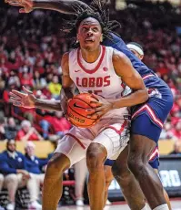  ?? GABRIELA CAMPOS NEW MEXICAN FILE PHOTO ?? JT Toppin eyes the basket March 6 as the Lobos face Fresno State in the Pit. Freshman sensation Toppin is among the players already represente­d by an agent for purposes like name, image and likeness agreements. Others may be represente­d by parents or other family members.