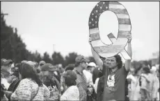  ?? ASSOCIATED PRESS FILE PHOTOS ?? A PROTESTER HOLDS A Q SIGN as he waits in line with others to enter a campaign rally in August 2018 with President Donald Trump in Wilkes-Barre, Pa. Candidates are breathing more oxygen into the once-obscure QAnon conspiracy movement that has grown in prominence since adherents won Republican congressio­nal primaries this year.