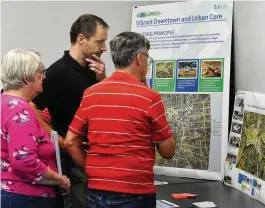  ?? MARSHALL GORBY\STAFF ?? Xenia City Planner Brian Forschner, center, talks with residents about “neXtPlan” (a 10-year roadmap for Xenia developmen­t) at an open house Tuesday at the Greene County media room.