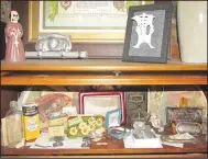  ?? ?? Burnett keeps much of her collection of death parapherna­lia in a glass-fronted bookcase she calls the Cabinet of Morbid Curiositie­s.