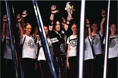  ?? — AFP photos ?? Japanese designer Keiichiro Yuri (center) and models greet at the end of the ‘Keiichiros­ense’ collection show at Amazon Fashion Week in Tokyo.