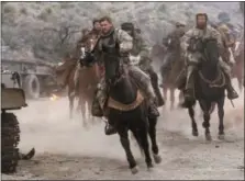  ?? DAVID JAMES/WARNER BROS. ENTERTAINM­ENT VIA AP ?? This image released by Warner Bros. Entertainm­ent shows Chris Hemsworth, center, in a scene from “12 Strong.”