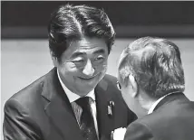  ??  ?? Japanese Prime Minister Shinzo Abe shakes hands with Haruhiko Kuroda, governor of the Bank of Japan