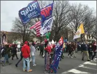  ?? ?? At the 2020 National March for Life in Washington, a marcher carrying a yellow-and-white Vatican flag marches past a vendor selling “Trump 2020” banners, several yards ahead of a banner for St. Joseph’s Parish in New York. While the Catholic Church took the lead in opposing legalized abortion, the movement now includes massive numbers of evangelica­l Christians as well. (Arkansas Democrat-Gazette/Frank E. Lockwood)