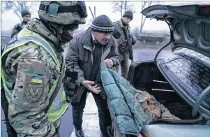  ?? AP PHOTO ?? Ukrainian national guard soldiers and a police officer search a car at the checkpoint near the city of Mariupol, south coast of Azov sea, eastern Ukraine, Tuesday.