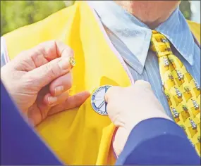  ?? Cassandra Day / Hearst Connecticu­t Media ?? Lions Club District 23 Governor Laura Rowe pins the Internatio­nal Lions pin on Marty Knight’s lapel. It is emblazoned with the motto “we serve in peace.”