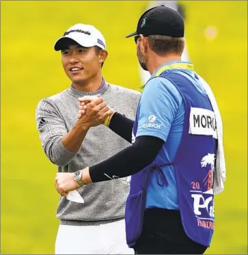  ?? Charlie Riedel Associated Press ?? COLLIN MORIKAWA, who graduated from La Cañada High, celebrates with caddie J.J. Jakovac after finishing his final round. Morikawa is only the fourth player to win a PGA Championsh­ip before his 24th birthday.