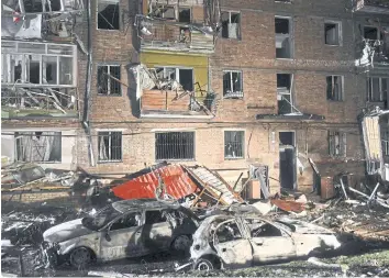  ?? AFP ?? Burnt cars in front of a damaged building following a Russian strike in the Ukrainian town of Vyshgorod on Wednesday.