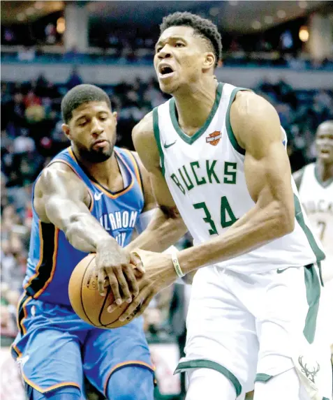  ?? ASSOCIATED PRESS ?? Oklahoma City Thunder's Paul George knocks the ball out of the hands of the driving Milwaukee Bucks' Giannis Antetokoun­mpo during the second half of an NBA basketball game in Milwaukee.