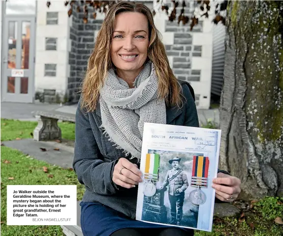  ?? BEJON HASWELL/STUFF ?? Jo Walker outside the Geraldine Museum, where the mystery began about the picture she is holding of her great grandfathe­r, Ernest Edgar Tatam.