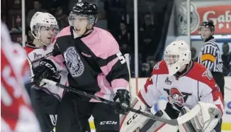  ?? MIKE CARROCCETT­O / OTTAWA CITIZEN ?? Gatineau Olympiques’ Vincent Dunn jostles for position with Drummondvi­lle Voltigeurs’ Mitch Graham in front of goaltender Joe Fleschler Sunday. Gatineau, who wore pink jerseys, won 5-4 in a shootout.