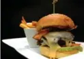  ?? RANDY RISLING/TORONTO STAR ?? The Star visited Azure Restaurant & Bar Thursday and ordered a burger. While the menu once incorrectl­y boasted a “Wagyu sirloin burger” — with high-end beef — there’s now a $28 beef brisket burger with “smoked bbq aoli, gouda, bacon, portobello...