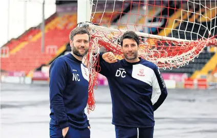  ??  ?? Net gain: Lincoln manager Danny Cowley (right) and his assistant, brother Nicky, receive half-time reports from their father
