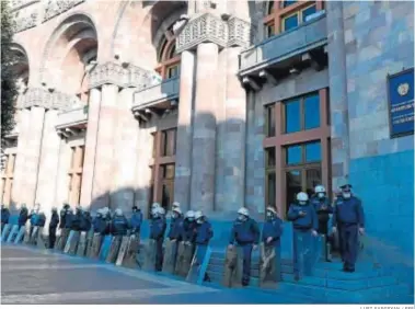  ?? LUSI SARGSYAN / EFE ?? Agentes armenios vigilan la sede del Gobierno en Ereván tras la firma del acuerdo de paz con Azerbaiyán.