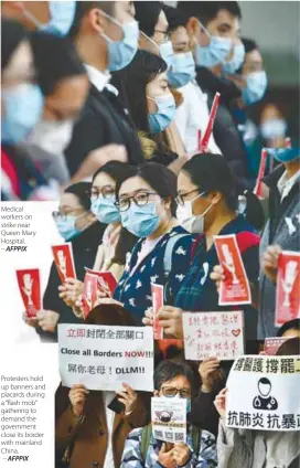  ??  ?? Medical workers on strike near Queen Mary Hospital. – AFPPIX
Protesters hold up banners and placards during a “flash mob” gathering to demand the government close its border with mainland China.
– AFPPIX