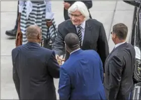  ?? THE ASSOCIATED PRESS ?? Attorney Tom Mesereau, center, shakes Bill Cosby’s hand as Cosby’s new legal team arrives Monday at the Montgomery County Courthouse in Norristown.