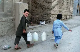  ?? WAKIL KOHSAR / AGENCE FRANCE-PRESSE ?? Afghan boys carry containers of water to their home in Kabul.